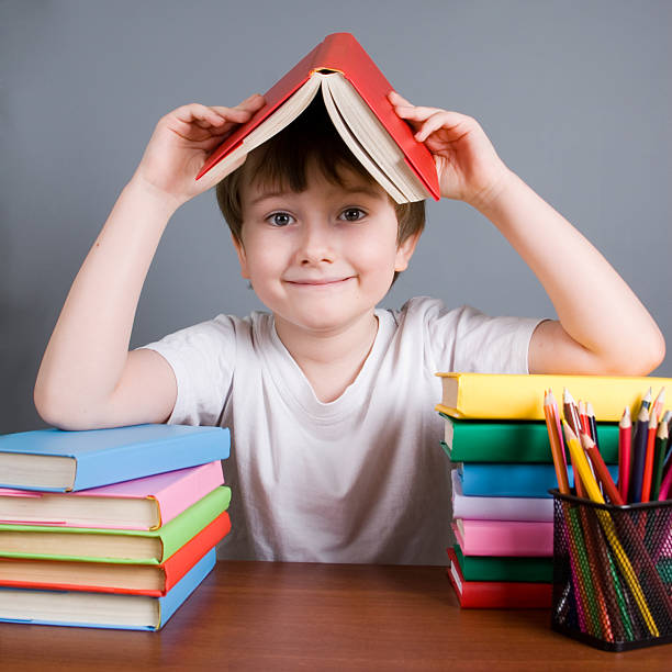 Boy with books on a gray background